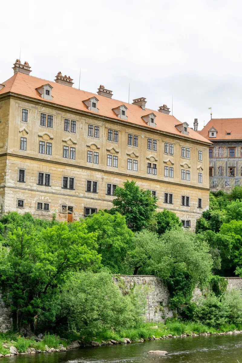 Der bemalte Renaissanceturm von Schloss Český Krumlov erhebt sich über den roten Dächern der UNESCO-geschützten Altstadt, in einer Hufeisenbiegung der Moldau in Südböhmen.